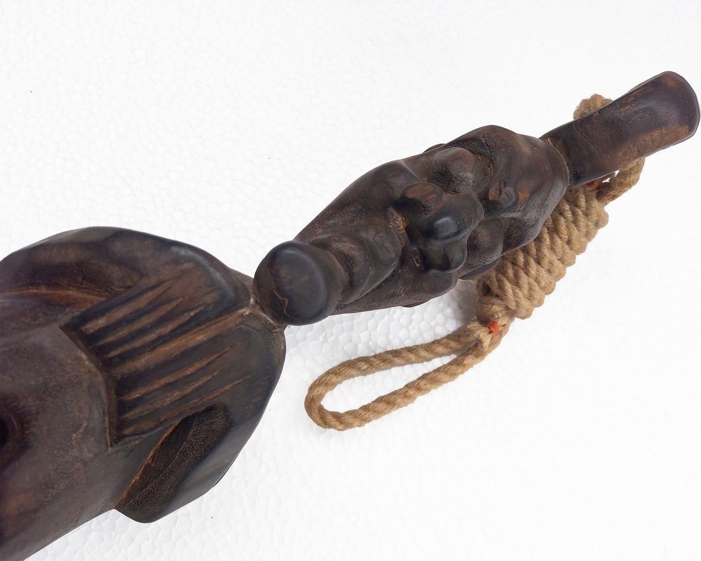 Wooden figure with rope detail on a white background