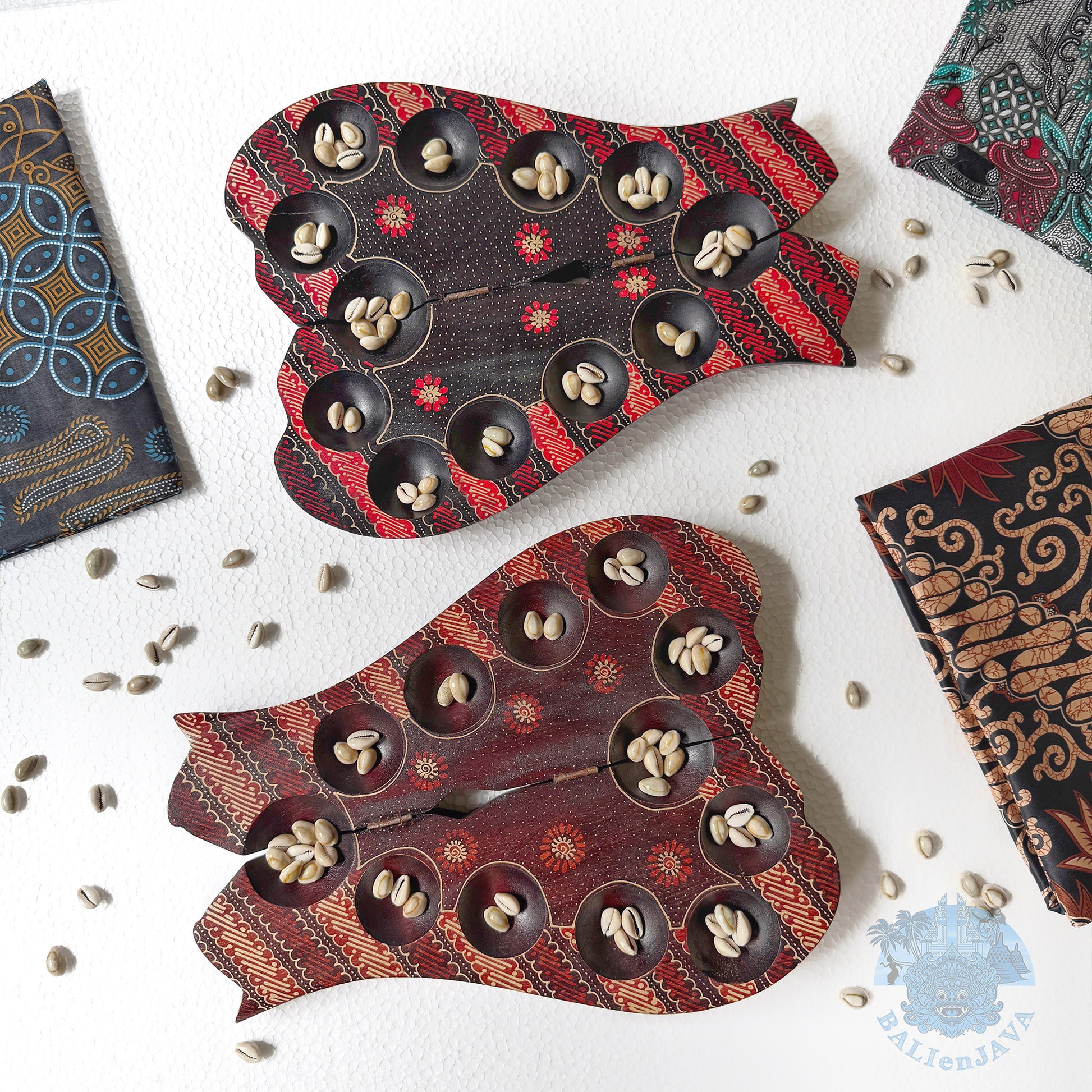 Decorative cat-shaped mancala with shells on a white surface.