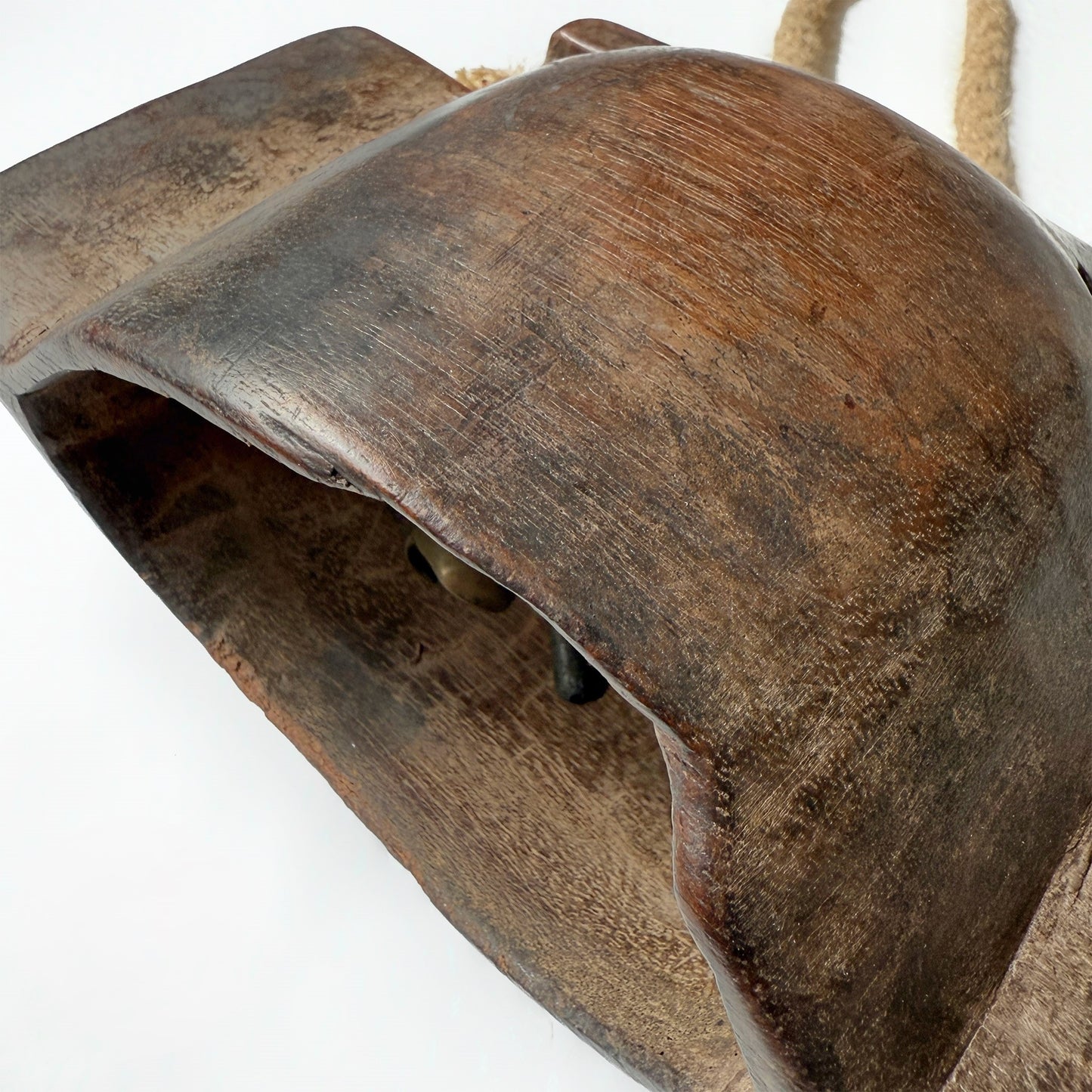 Close-up of a rustic wooden bell with a white background