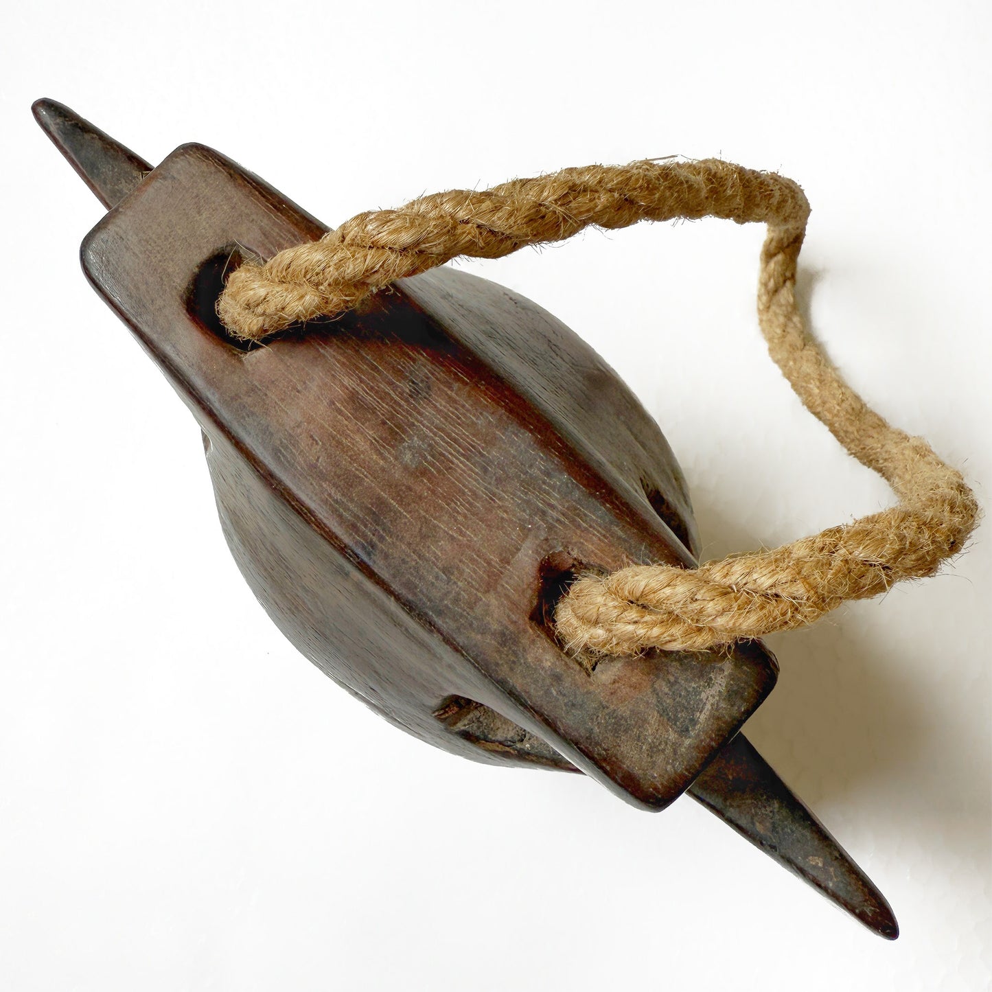 Top view of a wooden bell with a rope handle on a white background