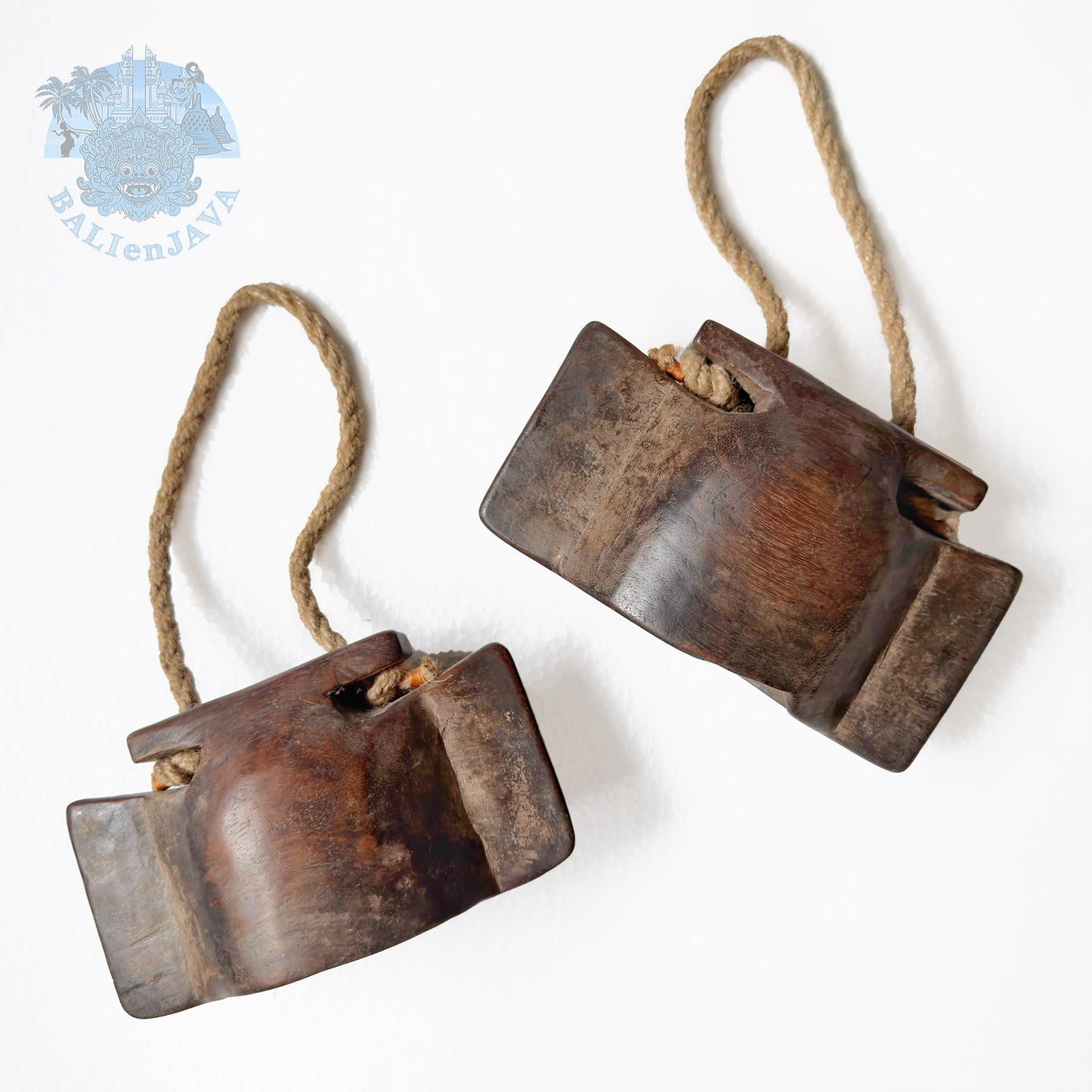 Two wooden bells with rope handle on a white background