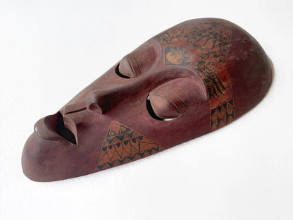 Wooden mask with tribal patterns on a white background