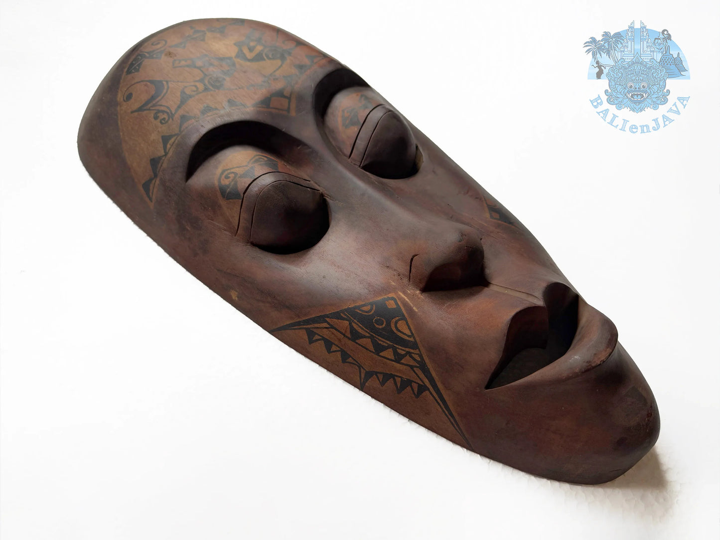 Wooden mask with tribal patterns on a white background