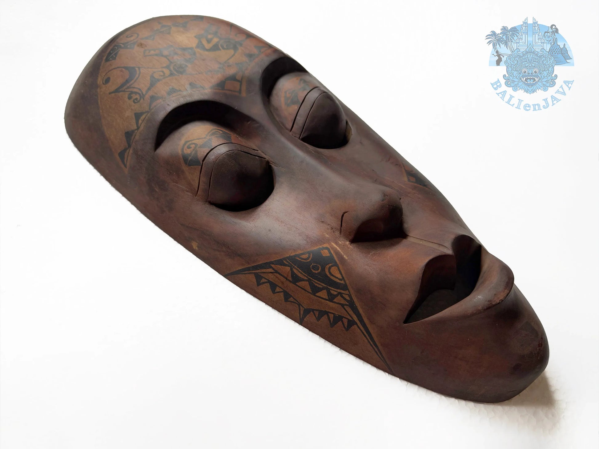 Wooden mask with tribal patterns on a white background