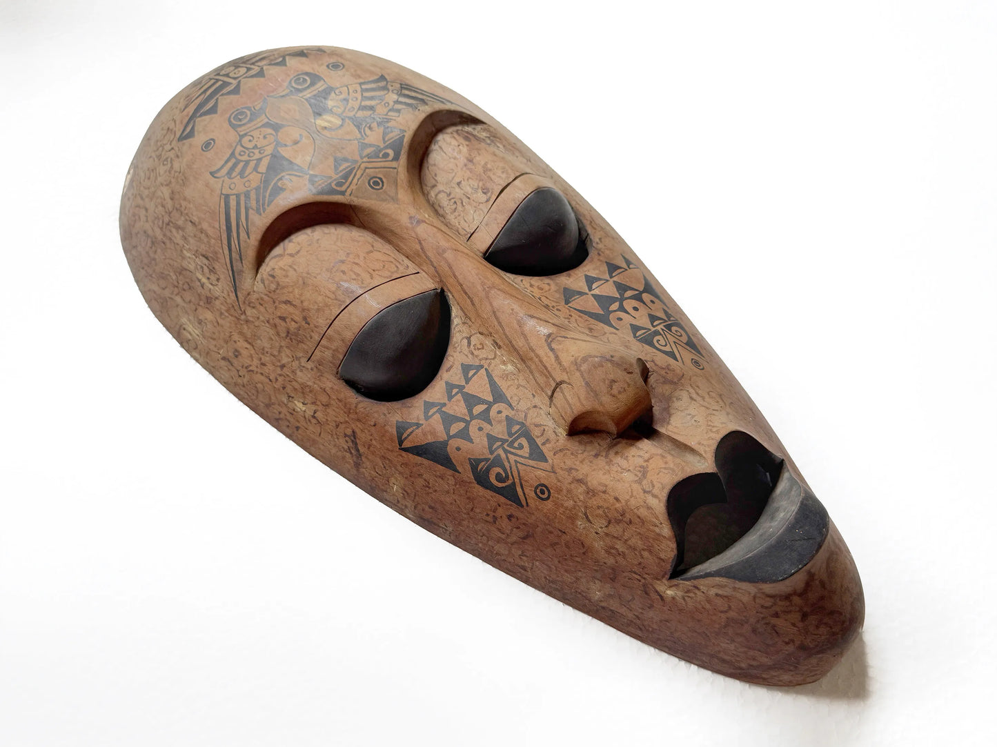 Wooden mask with tribal patterns on a white background