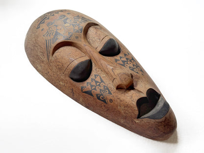 Wooden mask with tribal patterns on a white background