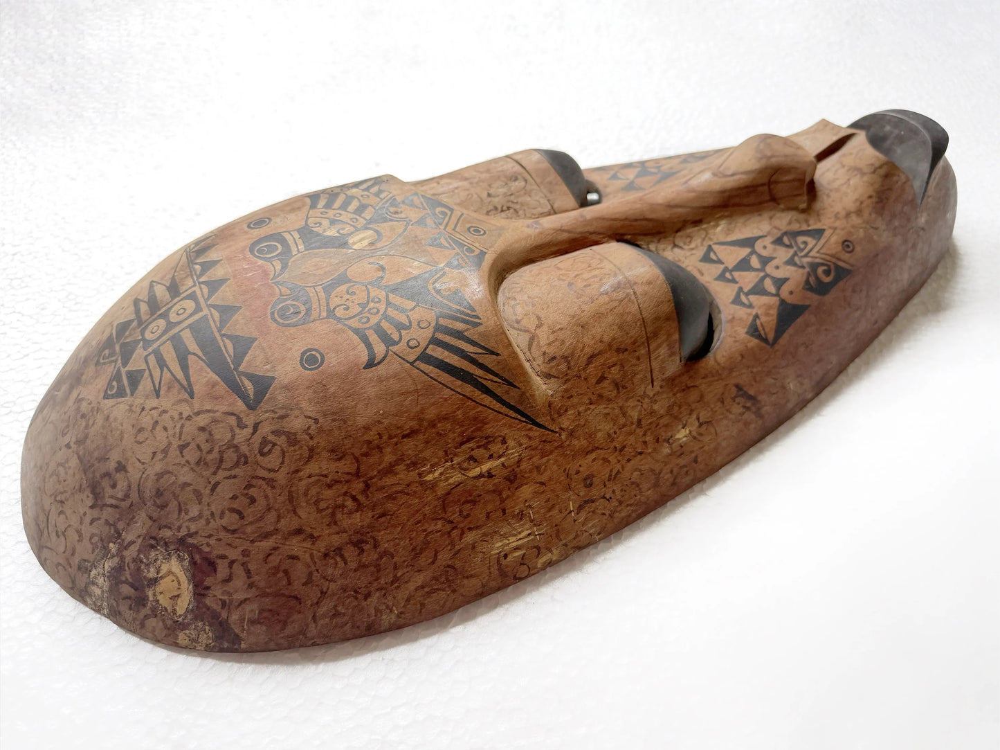 Detail shot of a wooden mask with tribal patterns