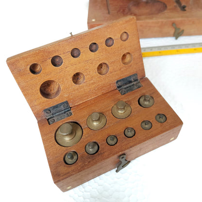 Scale weight set inside a small wooden box with brass clasp. 