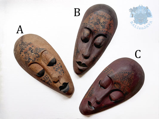 Three tribal wooden masks labeled A, B, and C on a white background
