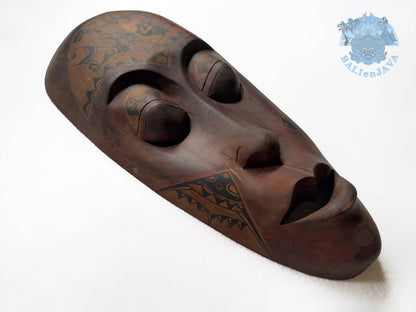 Wooden mask with tribal patterns on a white background