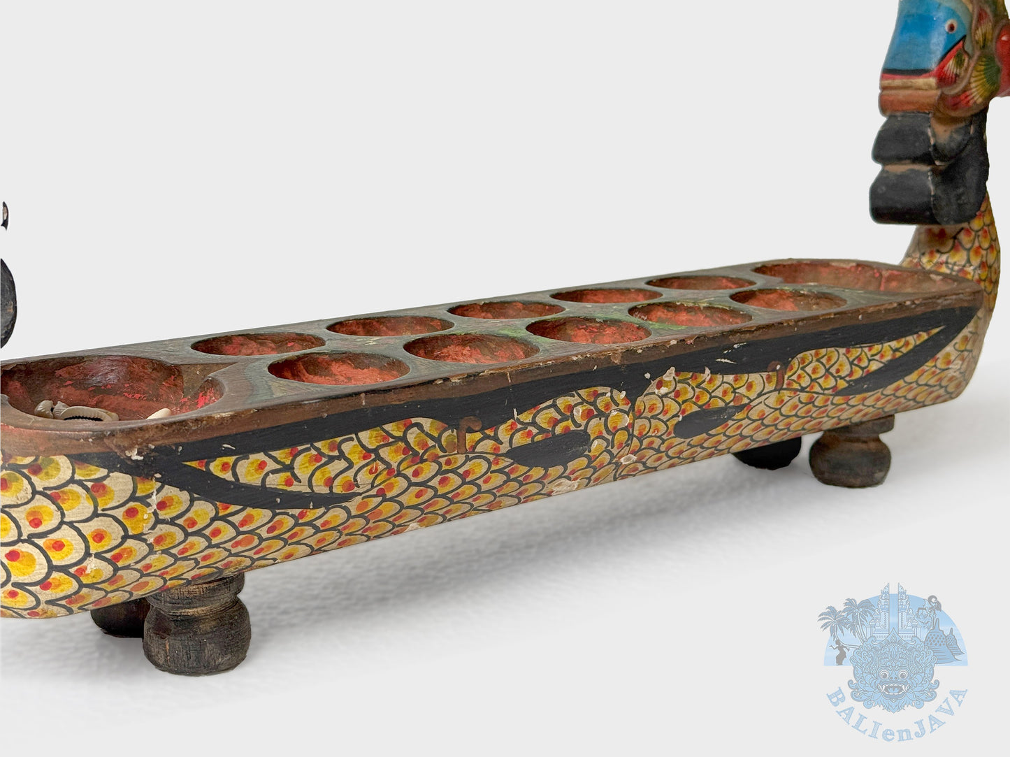 Decorative wooden object with snake scales design and compartments on a white background
