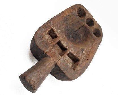 An old, hand-carved wooden pestle with signs of use on a white background.
