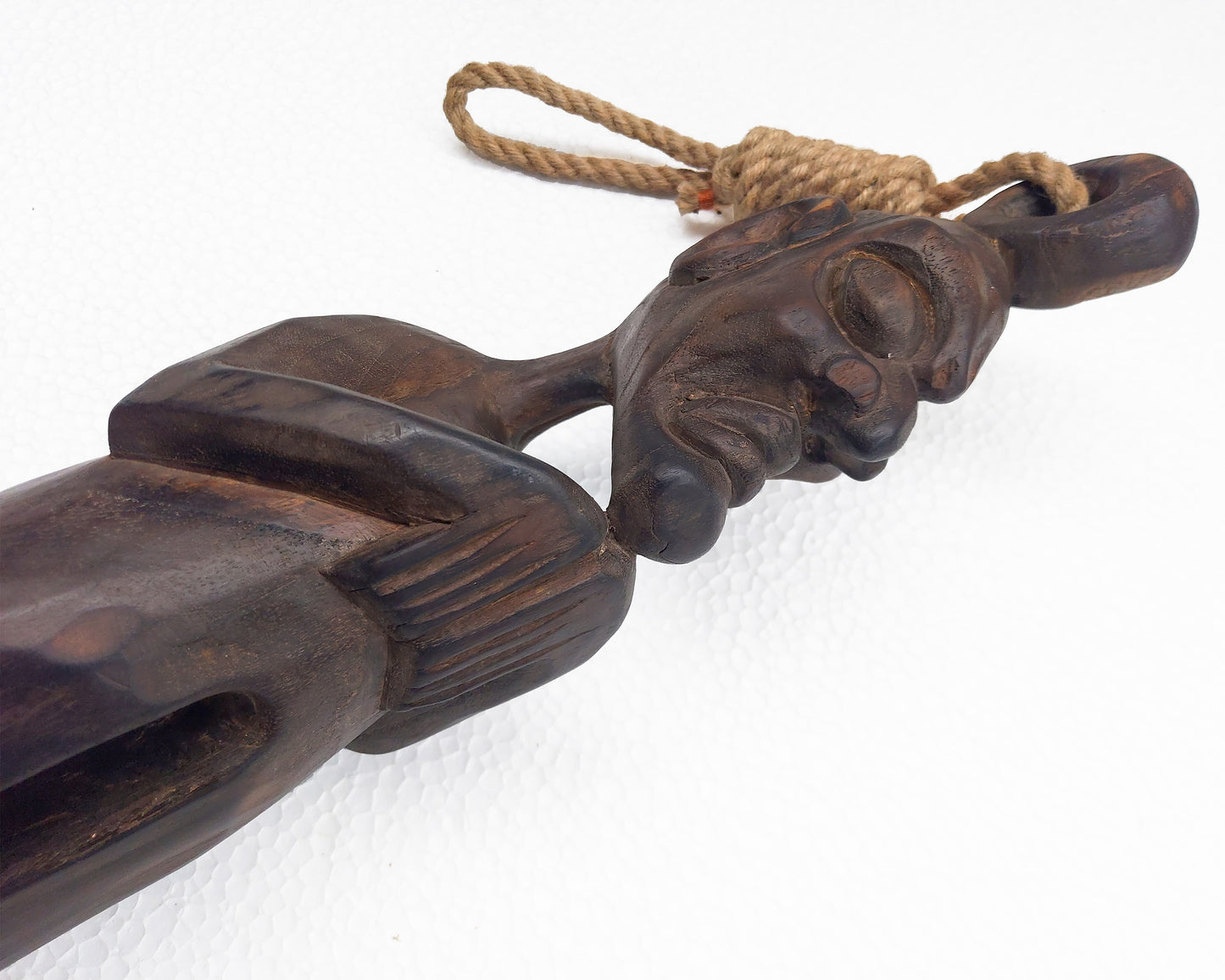 Carved wooden ethnic sculpture with rope on a white background