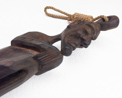 Carved wooden ethnic sculpture with rope on a white background