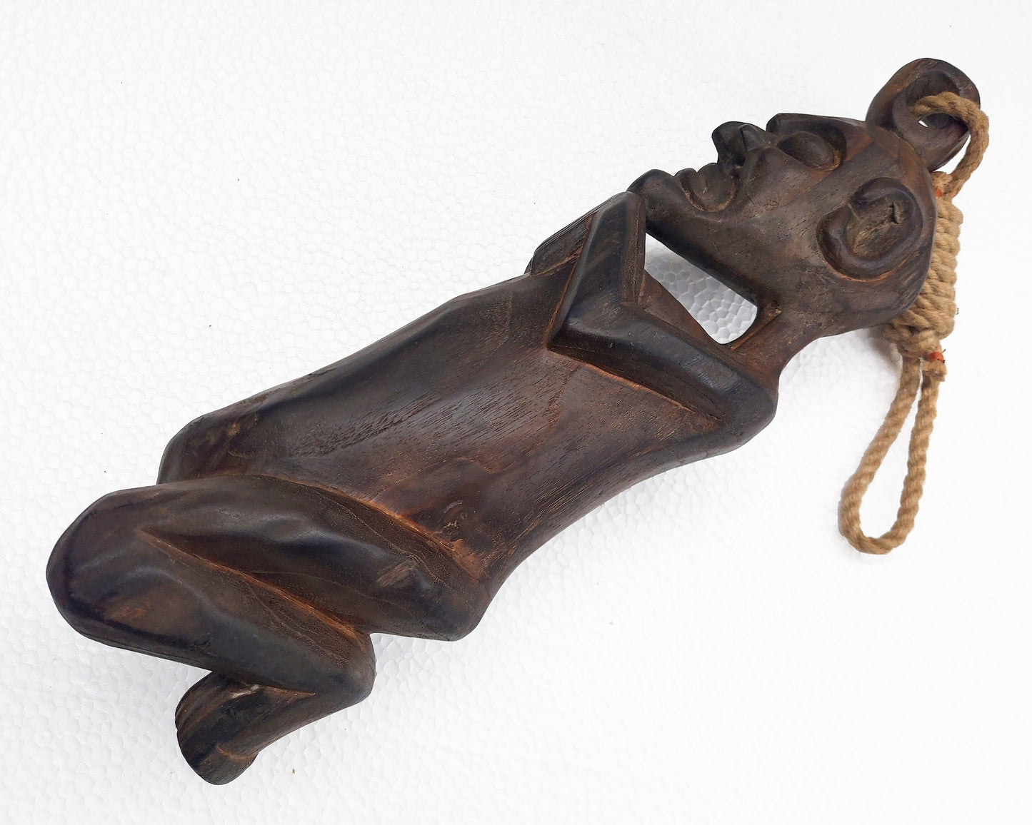 Carved wooden figure with a rope on a white background