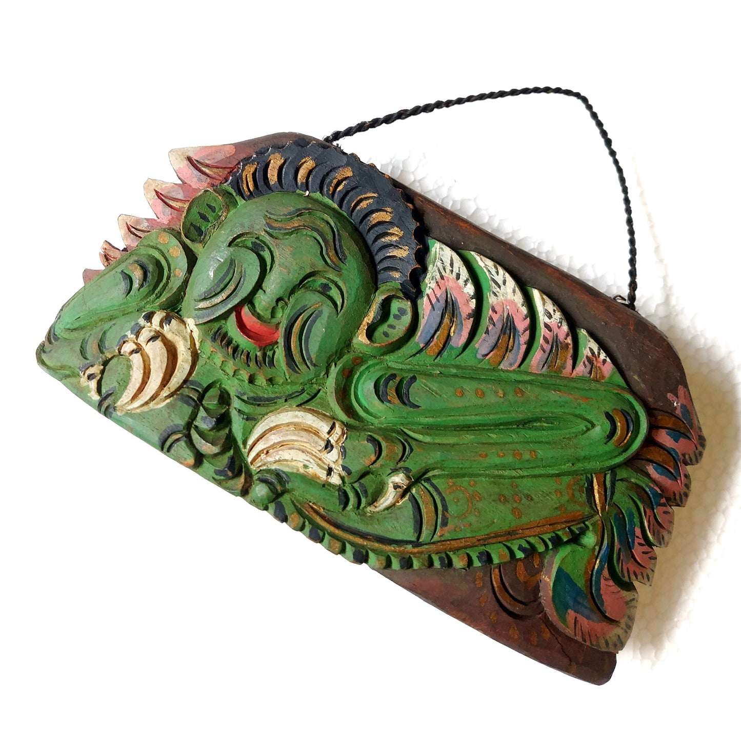 Wooden bell with carving of a green mythological creature and a rope handle