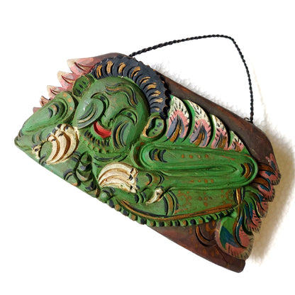 Wooden bell with carving of a green mythological creature and a rope handle