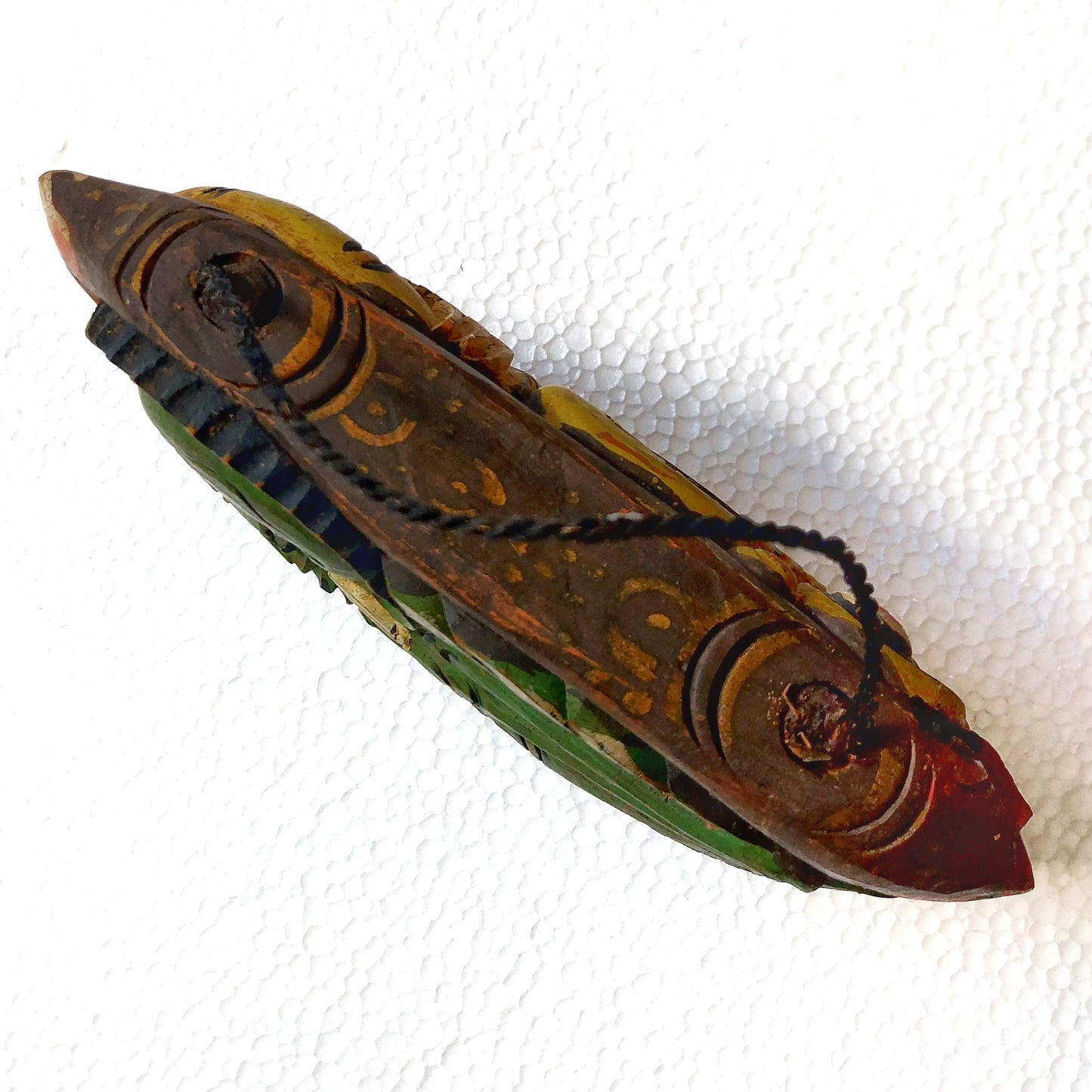 Top view of a wooden bell with rope handle on a white background