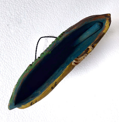 Bottom part of a wooden bell with the wooden clapper visible 