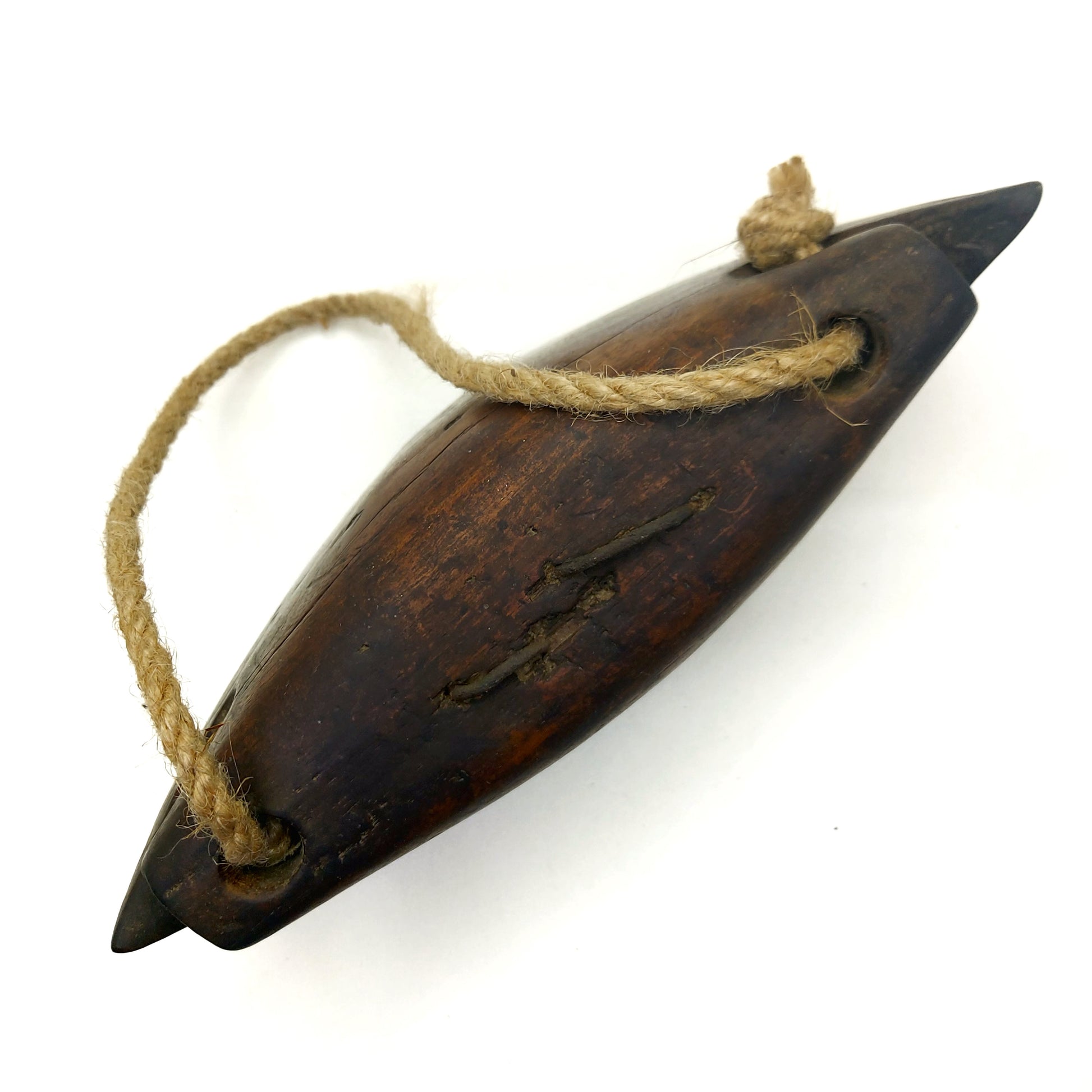 Top view of a wooden bell with a rope handle