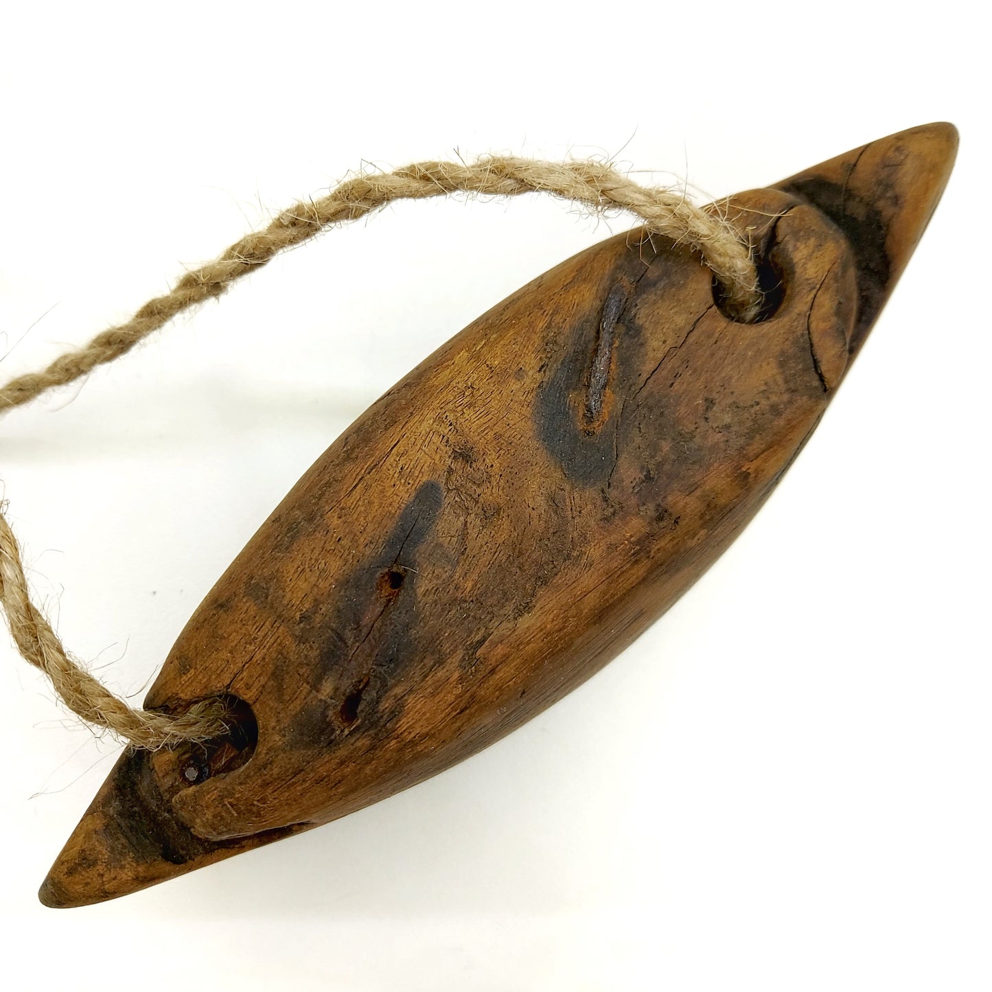 Top view of a wooden bell with rope handle connected to two holes 