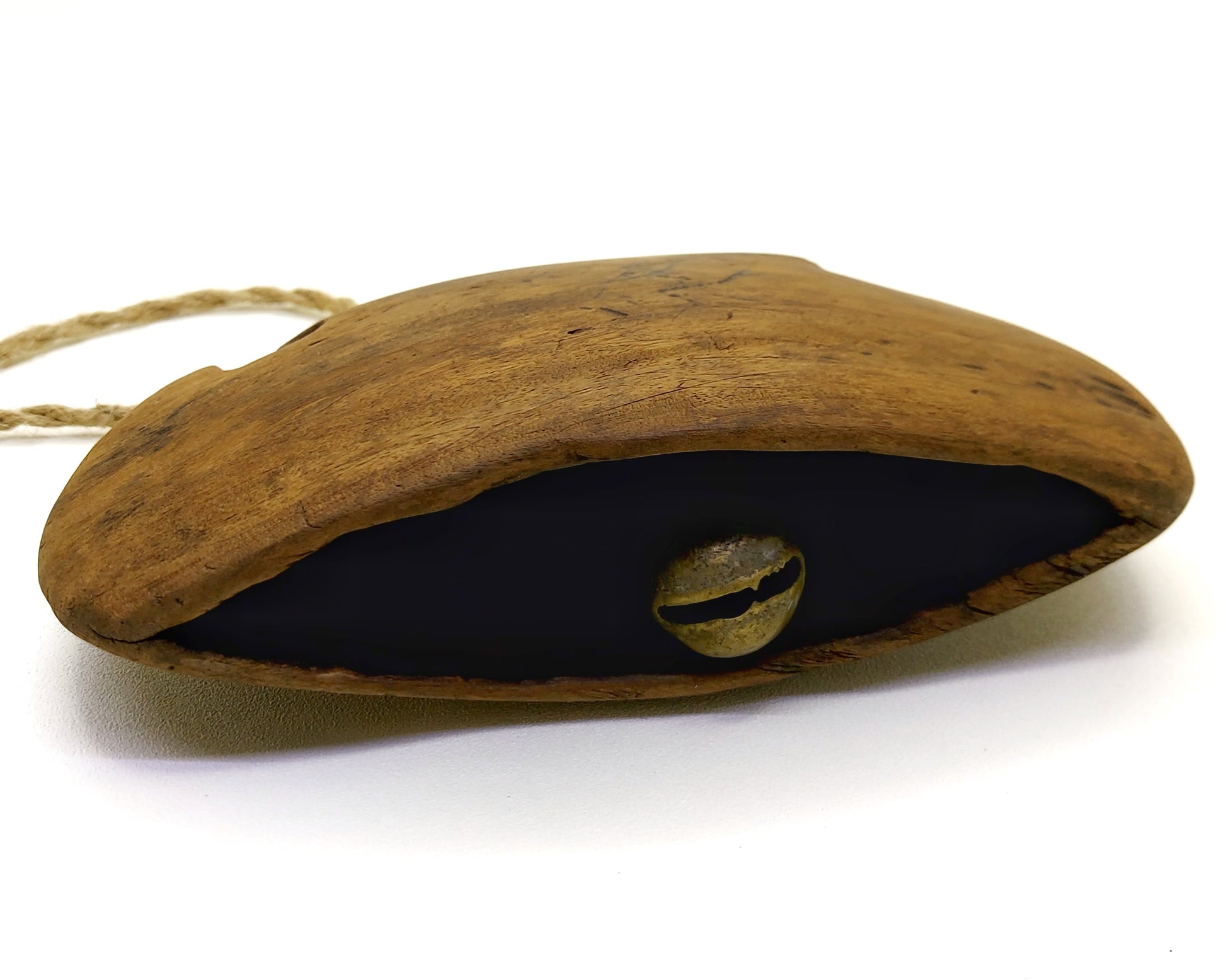 Curve shaped bottom part of a wooden bell with metal clapper visible 