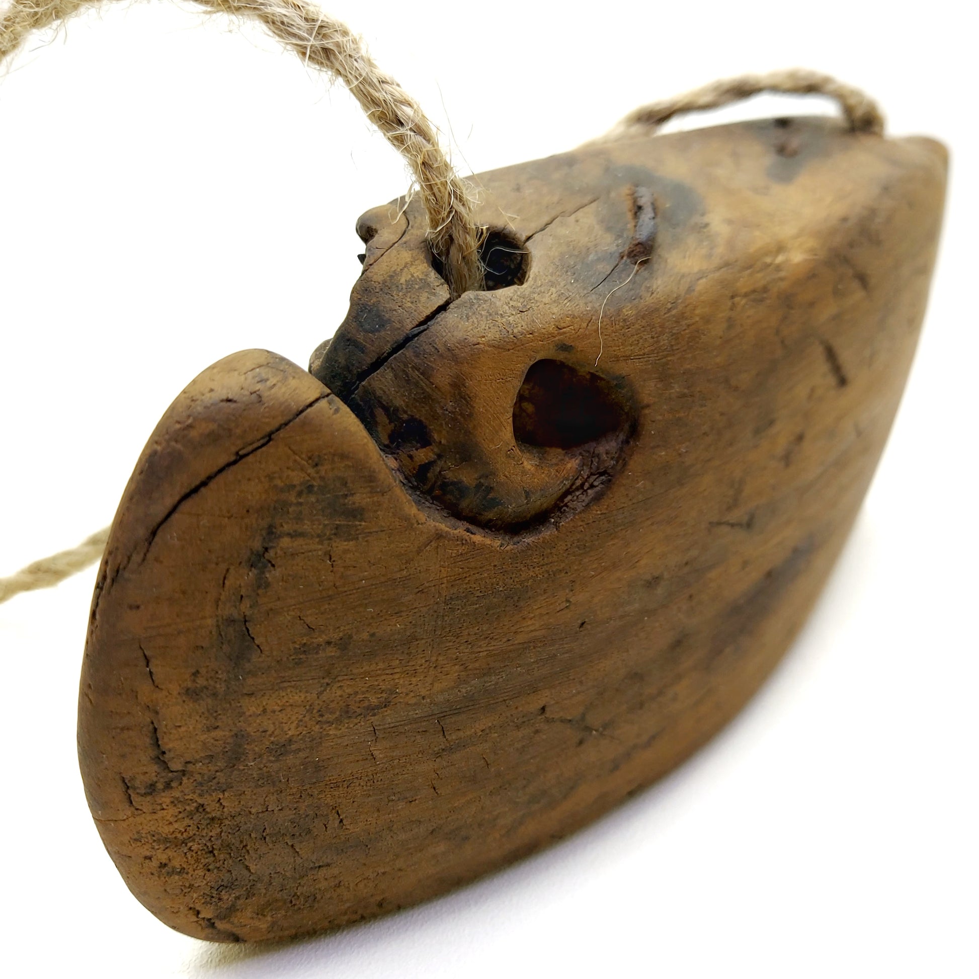 Side part of a wooden bell with fine cracked lines showing age of use