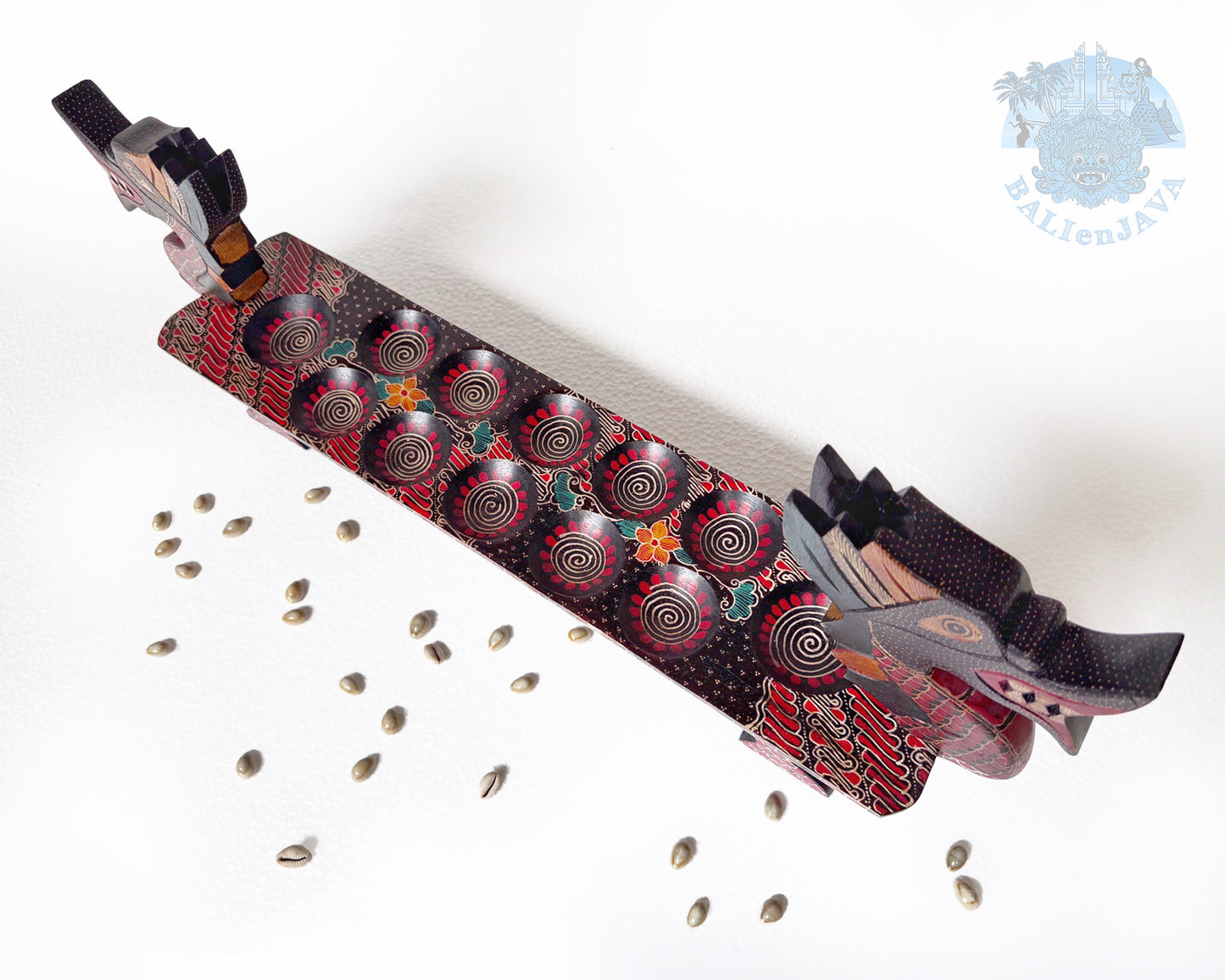 Dragon board game with patterned design and small seashells scattered on a white floor. 