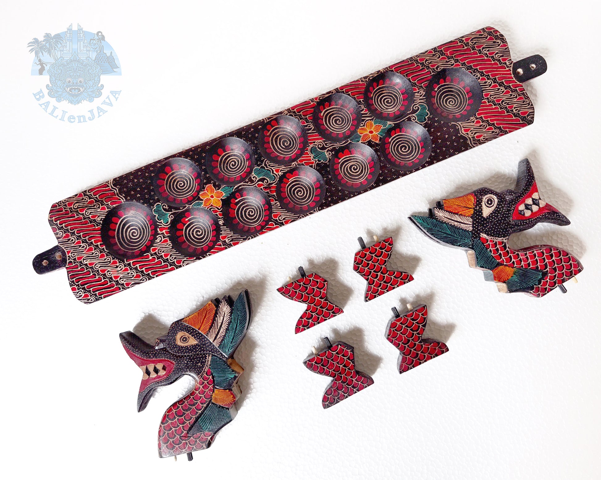 Detached parts of a colorful dragon-shaped board game with two heads and four legs on a white background.
