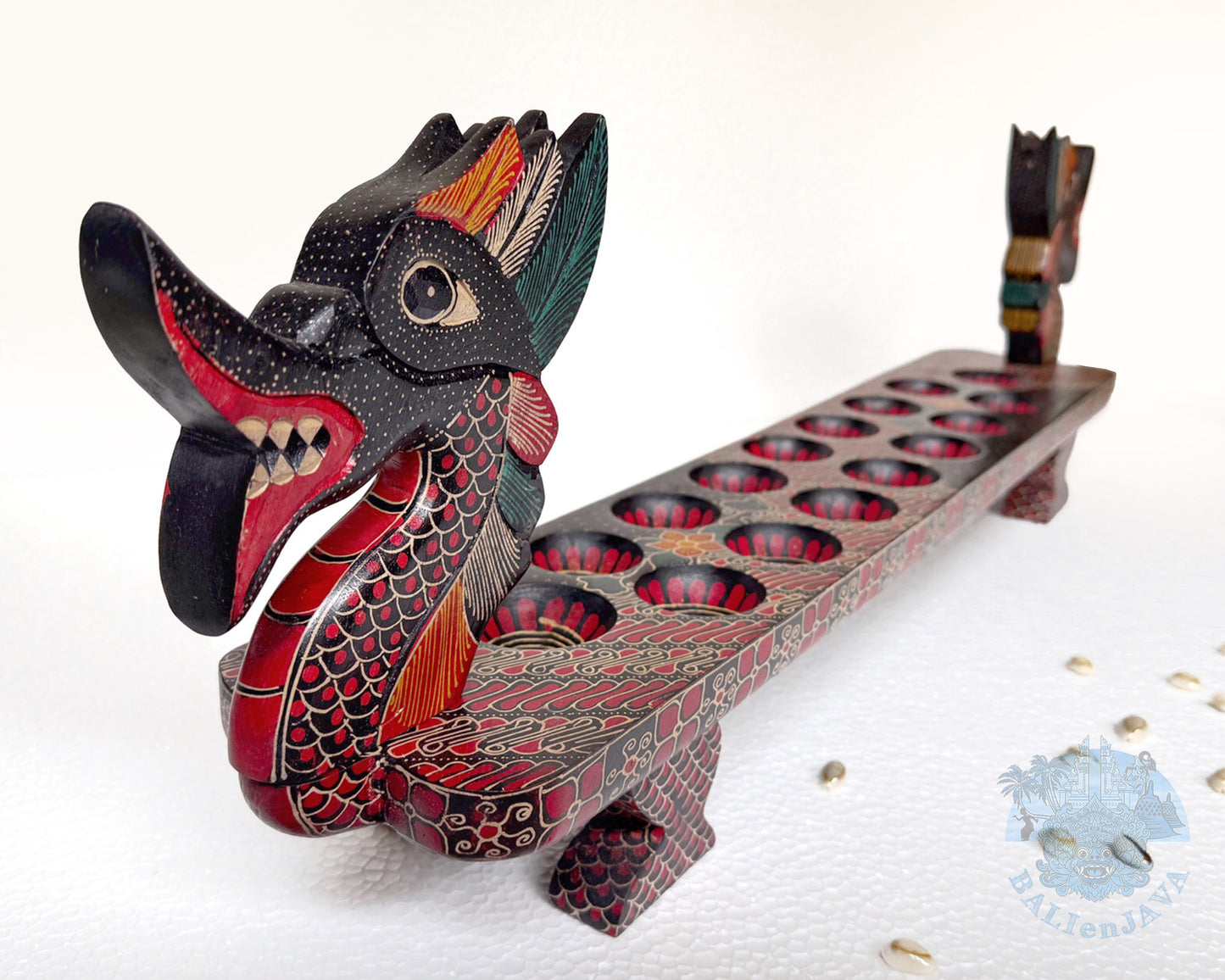 Mancala board game resembling a dragon with a long, narrow body and two heads with painted scales pattern.
