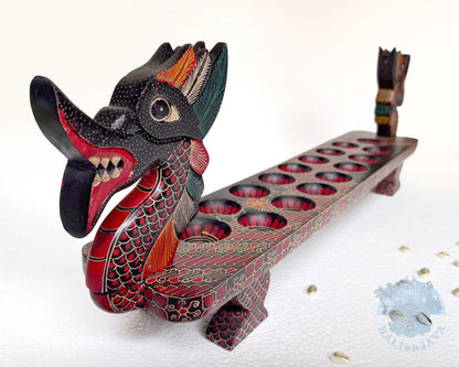 Mancala board game resembling a dragon with a long, narrow body and two heads with painted scales pattern.