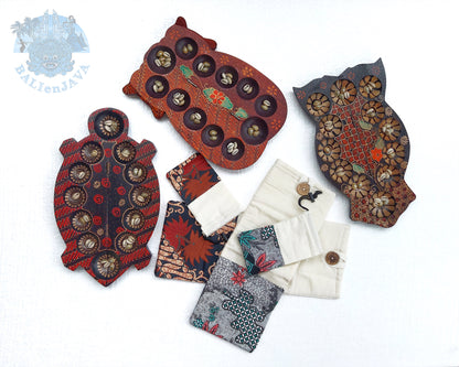 Collection of colorful mancala games with decorative pouches on a white background.