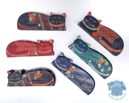 Six handcrafted wooden cat-shaped board game in various colors and patterns, arranged on a plain white background. 