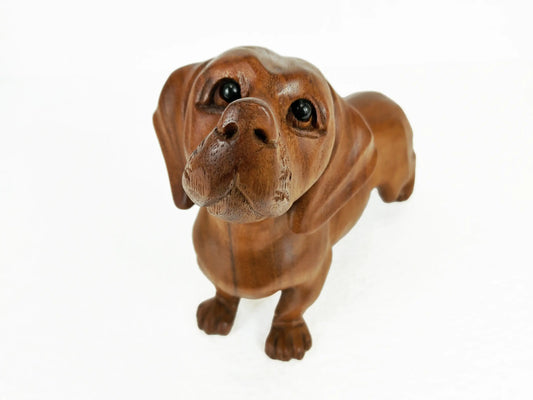 A realistic brown dachshund figurine with long floppy ears and large dark eyes, standing on a plain white background.