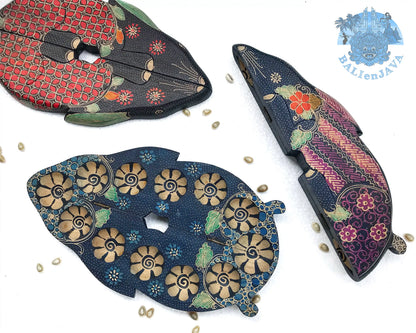 Three wooden rabbit-shaped board games with circular pits and intricate patterns, displayed on a white background with scattered cowrie shells.