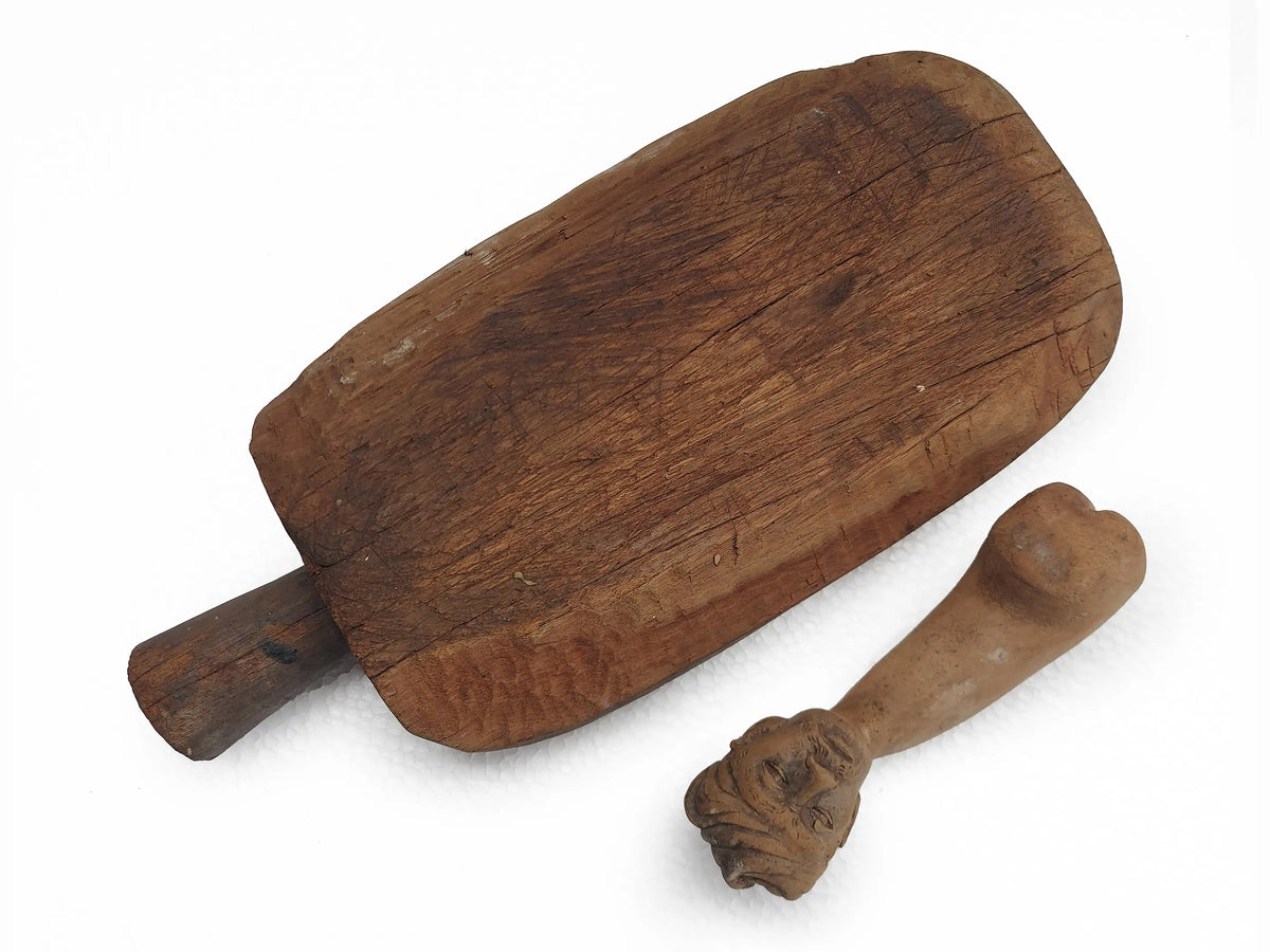 Back view of a carved wooden mortar and pestle on a plain white background.