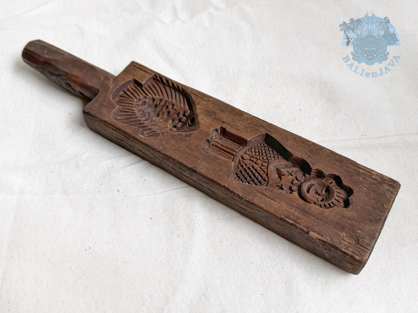 Wooden cookie mold with hand-carved design of a fish and a woman on a white background
