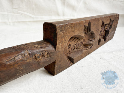 Wooden cookie mold with animal motifs on a white background