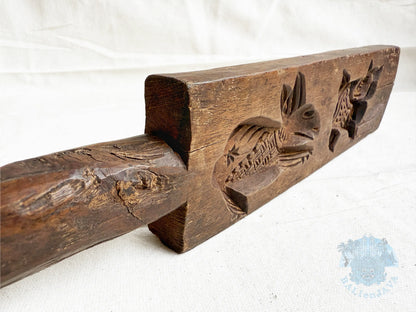 Wooden cookie mold with rabbit and cat carvings on a white background