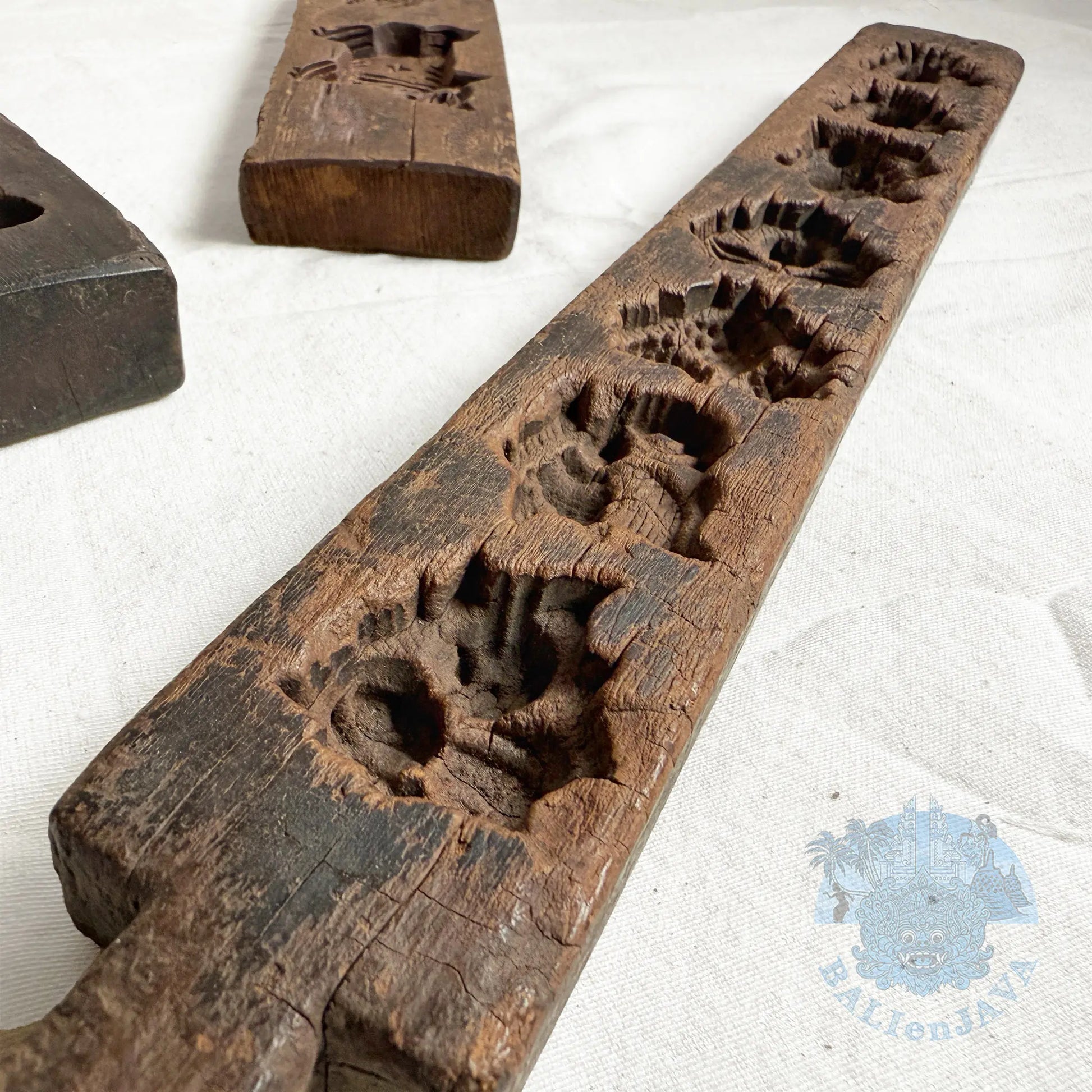 Close-up detail of a wooden mold with aged texture on a white background