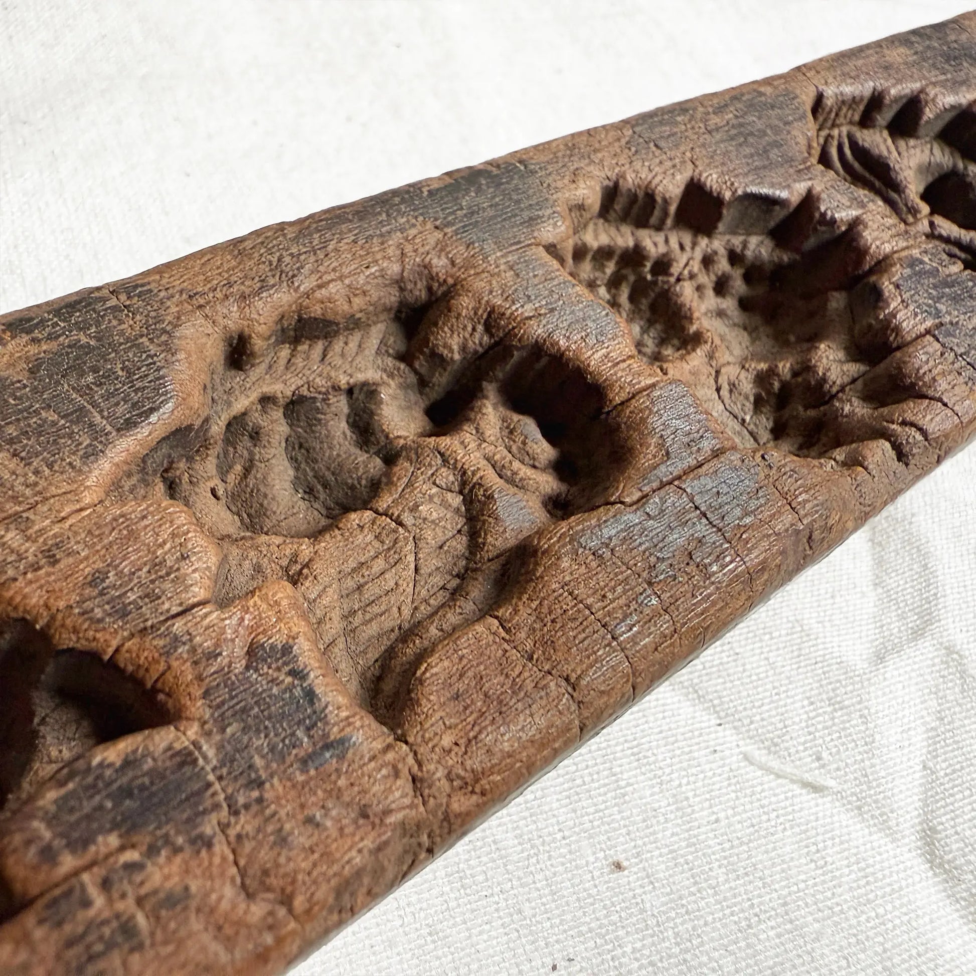 Wooden mold with carvings on a white background