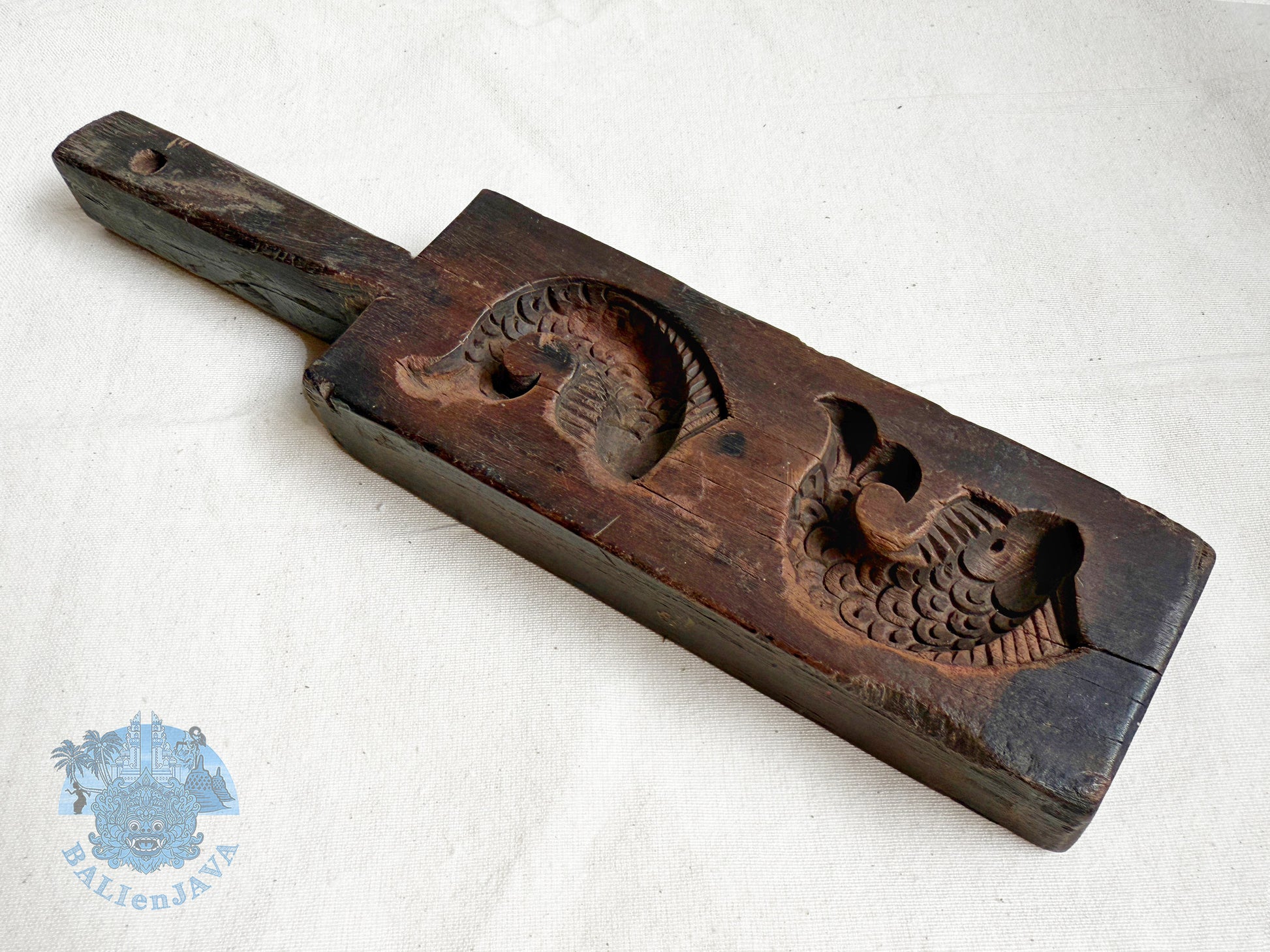 Wooden mold with two fish design on a white background