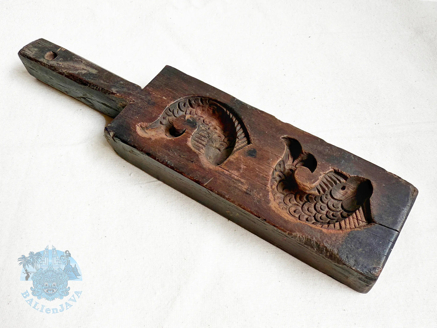 Wooden mold with two fish design on a white background
