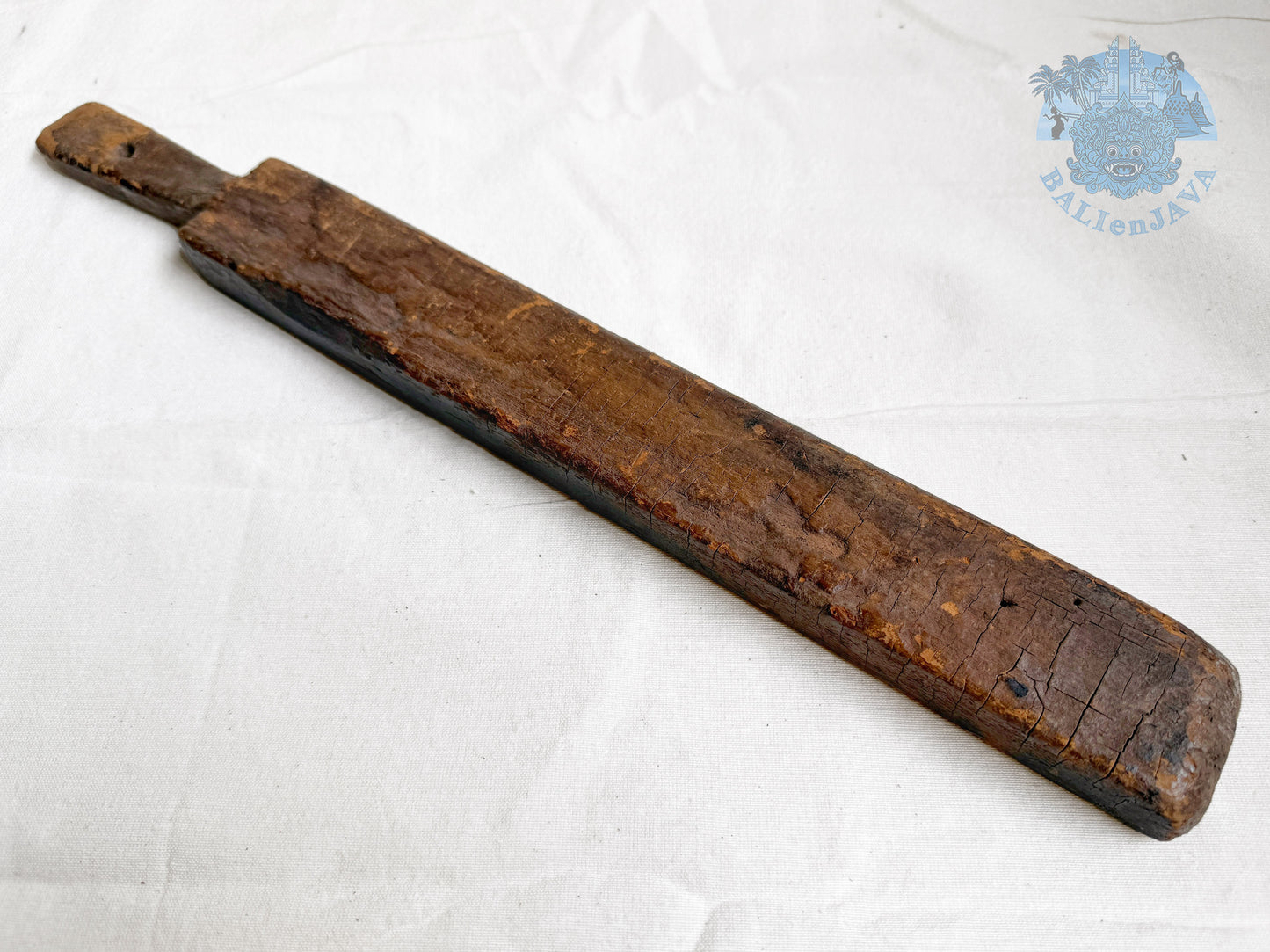 Long wooden cookie mold with a worn surface on a white background