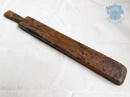 Long wooden cookie mold with a worn surface on a white background