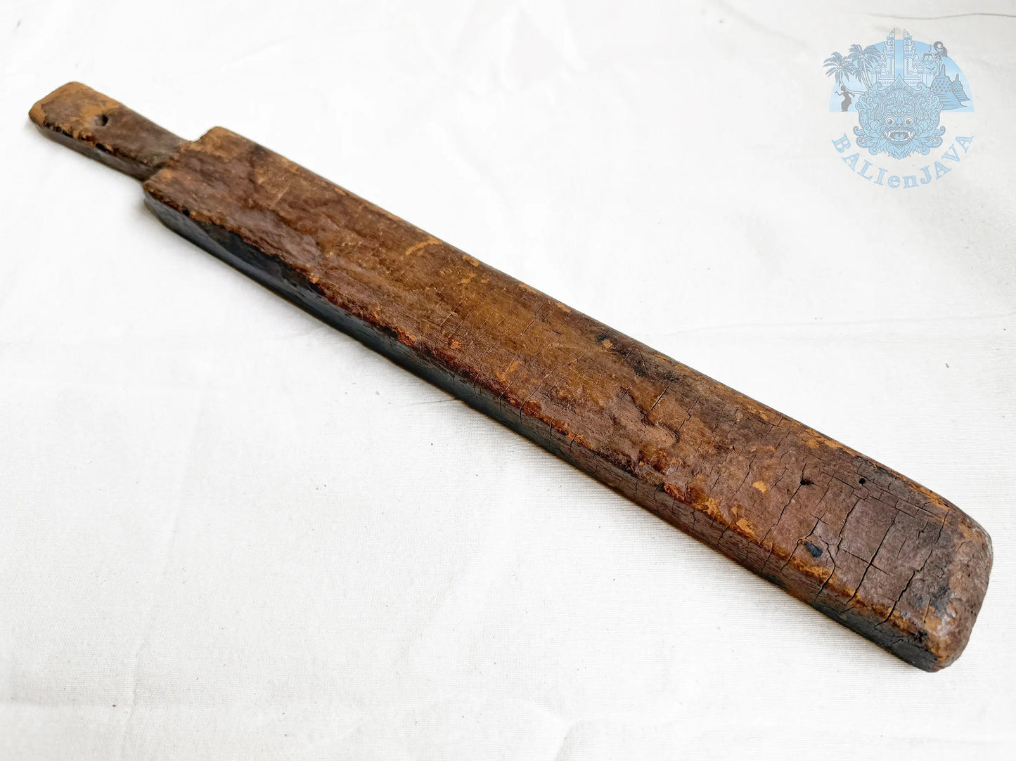 Long wooden cookie mold with a worn surface on a white background