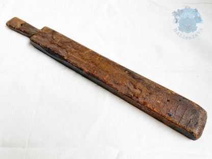 Long wooden cookie mold with a worn surface on a white background