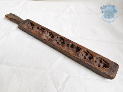 Old wooden cookie mold with decorative patterns and patina surface on a white background