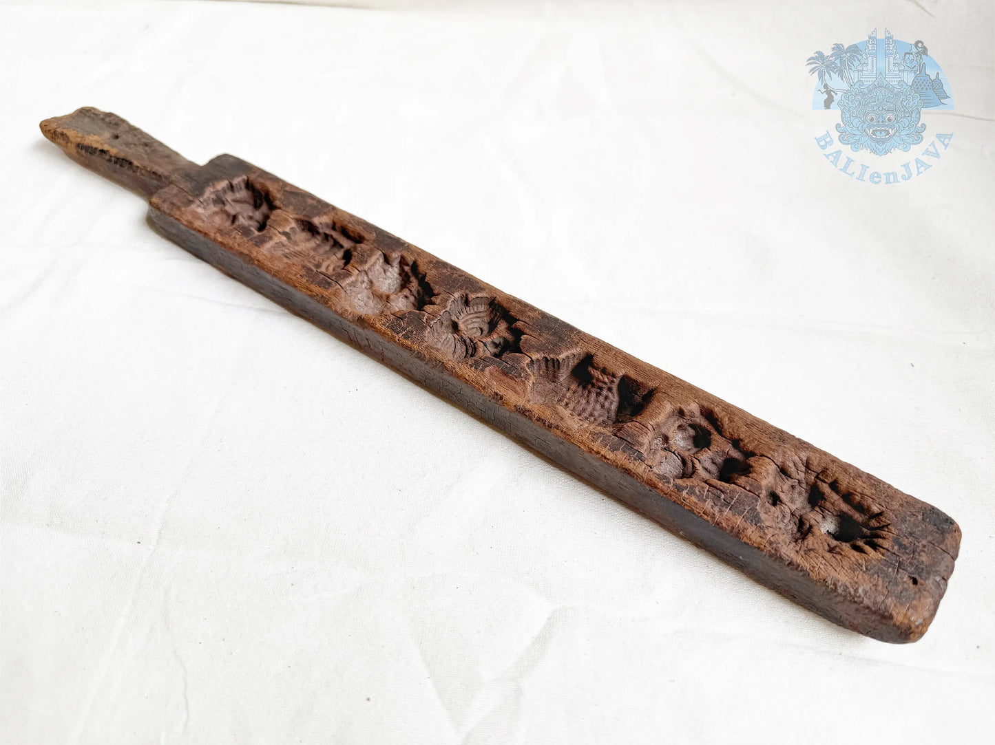 Vintage wooden cookie mold with aged texture and patina on a white background