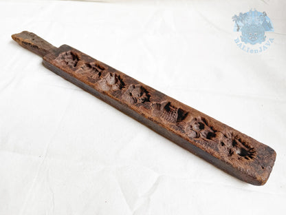 Vintage wooden cookie mold with aged texture and patina on a white background